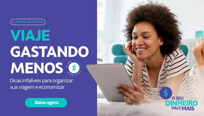 Banner de divulgação do e-book "Viaje Gastando Menos - Dicas Infalíveis para organizar sua viagem e economizar", de possível interesse para os leitores do artigo sobre as Férias de Julho. O banner possui uma imagem de uma mulher deitada confortavelmente lendo em um tablet. O banner também possui um botão "Baixe agora, indicado que ele é clicável. 